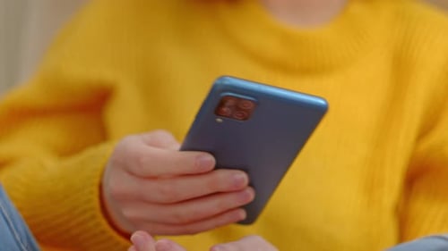 Girl texting on a blue smartphone with 4 cameras