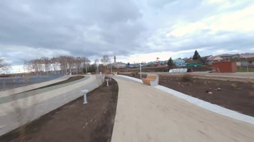 Empty Road and Channel in Young City Park Under Heavy Clouds