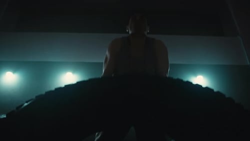 Strong Man Flipping Tyre While Practising in Crossfit Gym