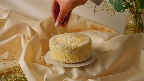 delicious freshly made sponge cake sprinkled with coconut shavings on the background of flowers