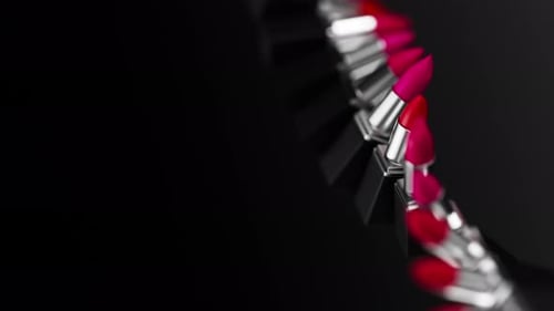 Verdrehte Reihe von Lippenstiften mit verschiedenen roten Farbtönen, rotierend auf schwarzem Hintergrund, schwarze Packung mit