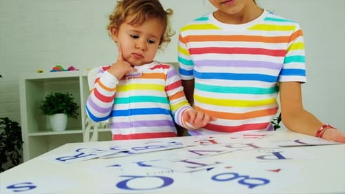 Child Learning Alphabet with Flashcards at Table
