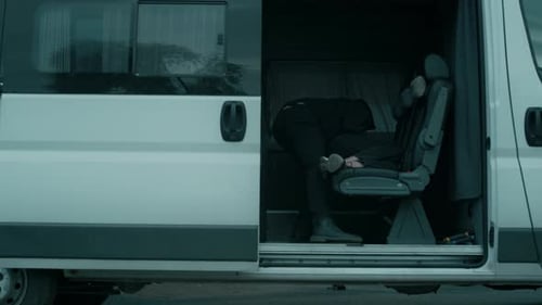 Anonymous Kidnapper in Mask Placing Unconscious Woman in Car
