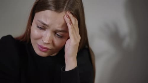 Sad Woman with Headache Holding Head in Anguish