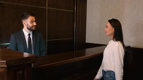 Female Guest Checking in at Hotel Reception Desk