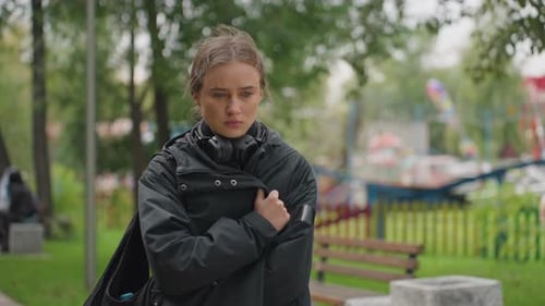 Worried Young Woman in a Park Looking Downcast