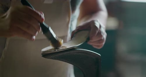 Close up of a shoemaker glueing the leather on the shoes in a shoe factory. Concept: handmade, fas