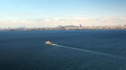 Aerial drone view of a floating ship on the Bosporus strait, view of Istanbul downtown on the backgr