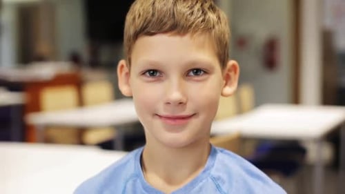 Boy Smiling in School Classroom, Close Up