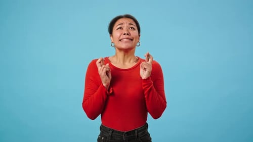 Woman Pleading, Praying, and Crossing Fingers for Luck