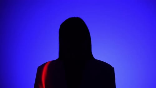 Une personne mystérieuse avec un effet de lumière bleu et rouge spectaculaire