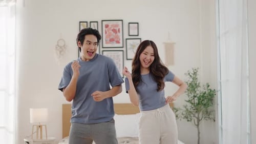 Cheerful Young Couple Dancing Together in Bedroom