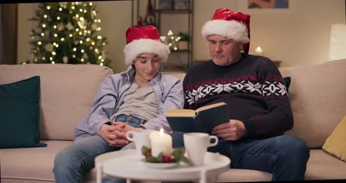 Teen and Adult Reading a Book at Christmas
