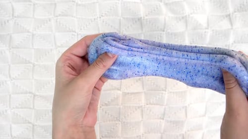 Playing with Textured Slime with Bubbles Stretching the Gooey Substance Female Teen Hand Holding