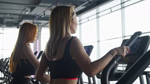Side View of the Hand Movements of a Young Woman Working Out on an Elliptical Trainer