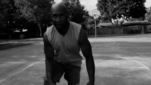 Intense one on one street basketball game in an urban park with black and white filter