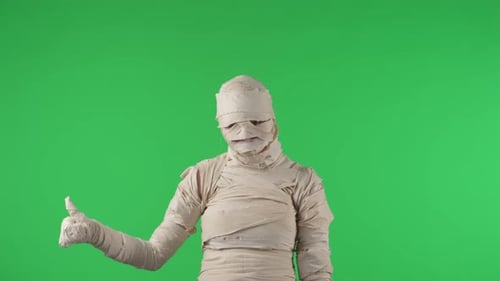 Vidéo à clé chromatique isolée sur écran vert capturant une momie donnant un pouce en l'air et hochant la tête