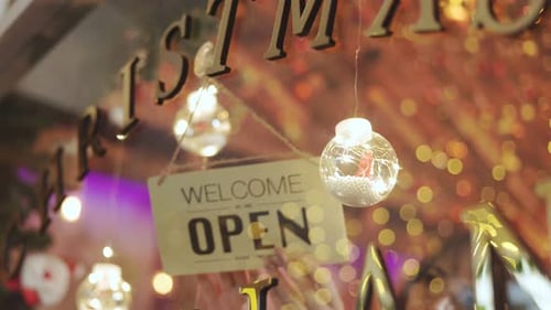 The woman shop owner flipping sign open to closed.
