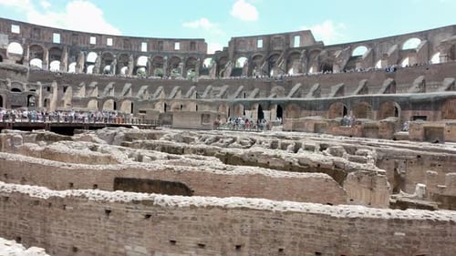 Crowds explore the ancient ruins inside the historic Colosseum in Rome on a bright sunny day