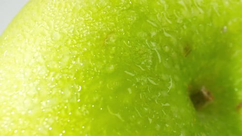 A green apple with droplets of water. macro video.