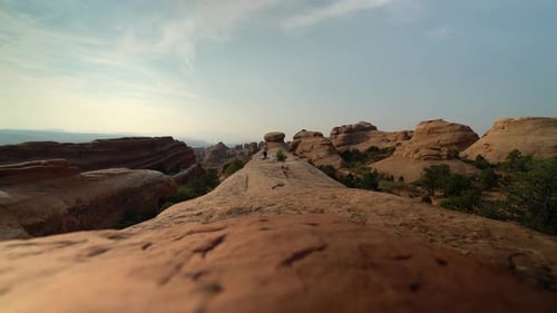 Low angle of man running on rock in Utah desert at sunset for health and wellness