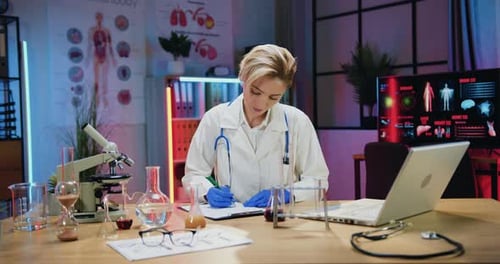 Woman doctor working with computer information and paper reports during overtime work in evening lab