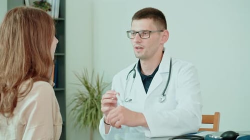 Doctor Examining Young Adult Female Patient in Office
