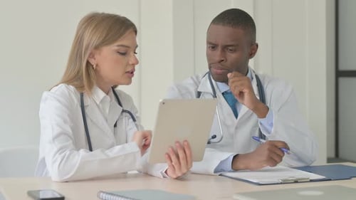 African Doctor and Female Doctor Working Together in Clinic
