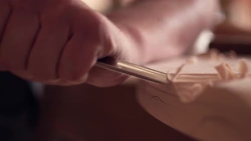 Close Up of Hands Using a Woodcarving Chisel on Wood