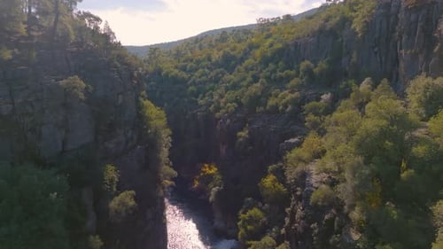 Aerial Drone Video Footage Flight Over the Shallow River Bed Between Green Rocks