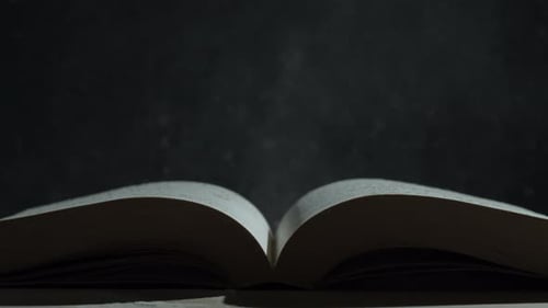 Open Book with Dust Floating in Dark Environment