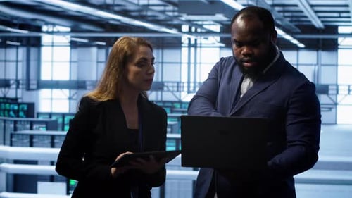 Coworkers in Server Room Optimizing Data Center Hardware Equipment
