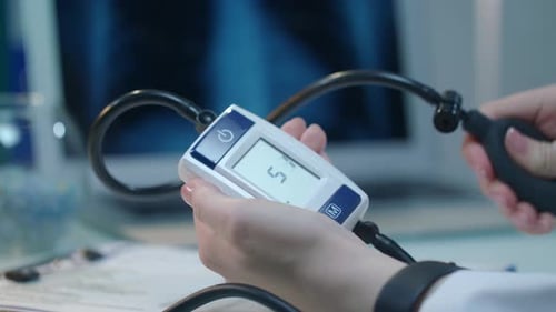 Main féminine utilisant un tensiomètre pour le diagnostic de l'hypertension en gros plan
