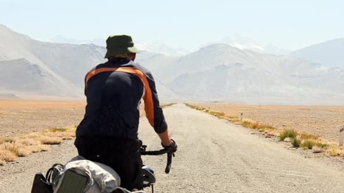 Cyclist Rides Through Arid Desert Landscape