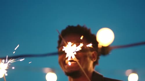 Homem negro, rindo ou dançando e brilhando na festa noturna no terraço, celebração de Ano Novo