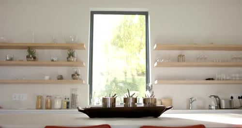 Sunlight floods a modern kitchen, highlighting the clean lines with copy space