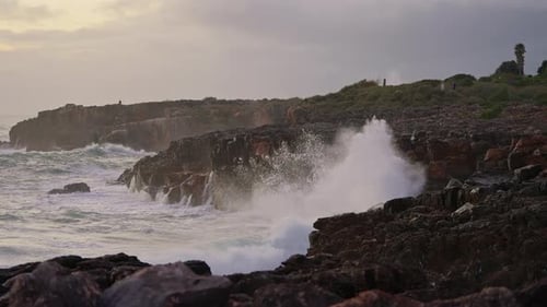 Waves Crashing on Rocky Shoreline at Golden Hour
