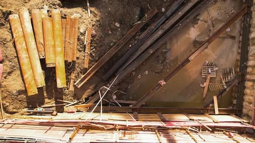 Vista aérea con un dron de la escena de contribución con escombros metálicos, una excavadora amarilla y un obrero de la construcción