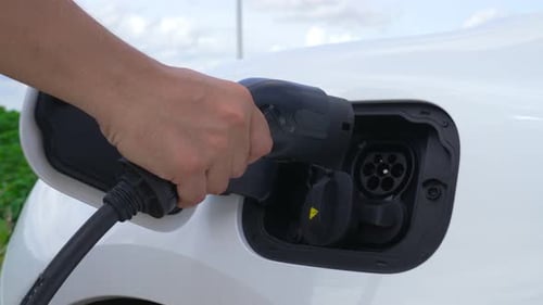 Progressive Man with His EV Car and Wind Turbine As Concept of Renewable Energy