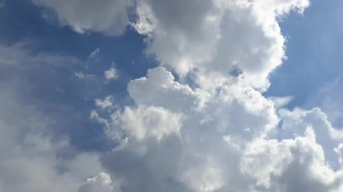 Blauer Sommerhimmel mit dichten, dichten Regenwolken, die sich über den Himmel ziehen. Schnelle Wolkenbildung und -bewegung