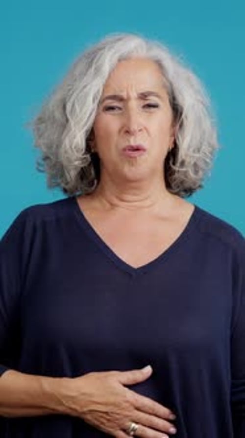 Mature Woman with Stomachache Blue Back Ground