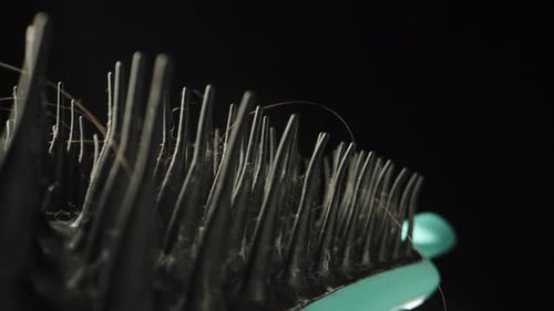 dirty black comb with hair, close-up rotation.