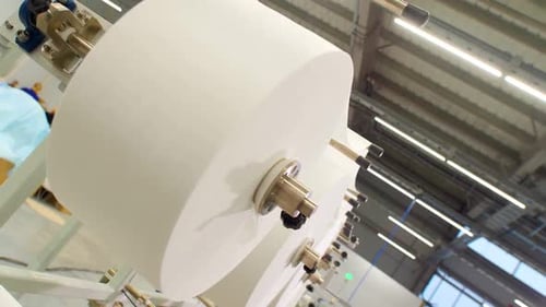 Industrial Machine Dispensing White Fabric in Factory