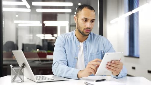 Man Works on Tablet in Bright Office