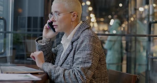 Stylish Person Working on Laptop and Talking on Phone