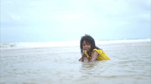 Portrait of children enjoying a playful walk on the beach as splash through the waves