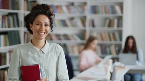 Young Happy Woman Student Carrying Books and Laughing to Camera Radiating Positivity and Ambition