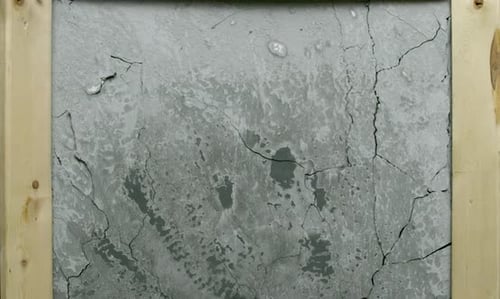 Impact Collection: Effect of a cracked grey textured concrete tile cracking up from inside