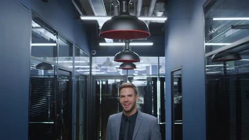 Happy businessman smiling posing in modern office hallway portrait at workplace