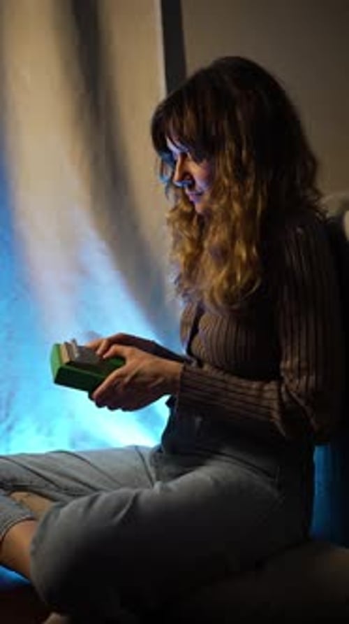 Musician Performing Kalimba Bathed in Blue Light Creating Serene Artistic Ambiance Through